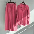 Detail view of retro pink linen two-piece set featuring oversized shirt and wide-leg trousers - Rose Red