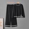 Detailed view of black knit two-piece set with contrast white stripes and side slit. - One Size / Top And Bottom / Black