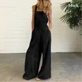 Close-up of black sleeveless wide-leg jumpsuit featuring side buttons and pockets - S / Romper / Black