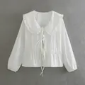 Elegant white long-sleeved blouse featuring a ruffled doll collar and tie-front bow design. - S / Tops / White