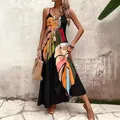 Detalle del colorido estampado de hojas tropicales en un vestido largo bohemio negro - Colores Mezclados
