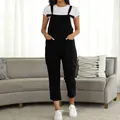 Detailed front view of women's casual black overalls jumpsuit over a white T-shirt - Black