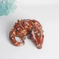 Close-up detail of a resin dragon figurine filled with red natural crystal stones. - Red Jasper With White Sequins