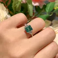 Detalle exquisito de un anillo de moissanita verde azulado corte radiant con piedras. - US 5 / 2 Quilates Azul Verde Radiant (S925 Plata Chapada)