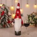 Festive Christmas gnome wine bottle cover with red knitted snowflake hat and white beard - Holding Kerosene Lamp Style / Red