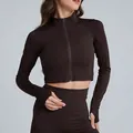 Dettaglio di una giacca da yoga marrone slim-fit corta con cerniera e asole per i pollici. - Taglia S / Top / Caffè Distillato