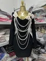 Close-up of black bandage dress with multi-layer pearl necklaces and flower appliques. - S / Dresses / Black