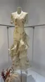 Detailed view of cream floral V-neck dress featuring elegant multi-layered ruffle hem. - XS / Dresses / Yellow