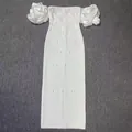 Macro detail of elegant white bodycon maxi dress with puffy sleeves and rhinestones - S / Dresses / White