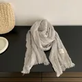 Detail view of light grey pleated cotton-linen scarf with fringed edges and label - Light Gray