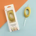 Premium golden number 0 birthday candle in retail packaging on a split color background - Number 0 / Gold