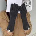 Detail view of women's warm grey knitted gloves with minimalist white labels for winter - One Size / Dark Gray