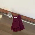 Top down view of purple 100% wool convertible mittens on a wooden table surface - Solid Color Flip Top / Dark Plum Purple