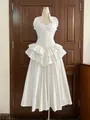 Detailed view of white pleated maxi dress with corset waist and tiered ruffle hem - White