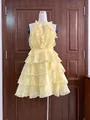 Détail d'une élégante robe jaune à volants en mousseline sur un mannequin d'étalage. - Light jaune