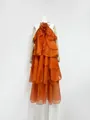 Detail view of orange tiered ruffle maxi dress with 3D floral accent on mannequin - Orange