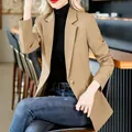 Nahaufnahme eines schmal geschnittenen khakifarbenen Damenblazers mit Goldknöpfen. - Khaki