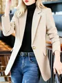 Eleganter, schmal geschnittener beiger Damenblazer mit blauer Jeans und schwarzem Top - Aprikose