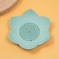 Detalle de jabonera de silicona azul claro en forma de loto con orificios de drenaje - Verde claro