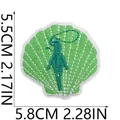 Detailansicht eines grünen Stickaufnähers in Muschelform mit Surferin für Kleidung - Muschel Surfermädchen Stil (X25HL-102-08)