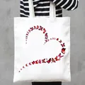 Detailed view of white canvas tote bag featuring a vibrant red butterfly heart print. - Red Butterfly Heart Style (19)