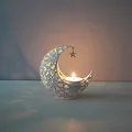 White hollow moon iron candle holder with star pendant and a glowing tea light candle - White
