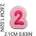 Detailansicht des rosa gestickten Aufnähers Nummer 2 mit Größenangaben 2,6 cm x 2,1 cm. - Zahl 2 Stil (X20YF-06-03) / Rosa