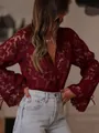 Macro view of a burgundy hollow-out lace blouse showing intricate floral patterns - Burgundy
