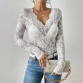 Primo piano dettagliato di un top in pizzo floreale bianco con scollo a V smerlato - Taglia S / Top / Bianco