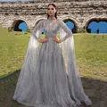 Elegant grey sequined mesh evening gown with long cape sleeves and tassel details - S / Dresses / Gray