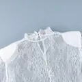 Gros plan détaillé du tissu en dentelle florale blanche d'une robe à col montant - S / Robes / Blanc