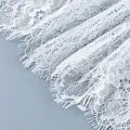 Gros plan sur les détails complexes de la dentelle blanche aux motifs floraux délicats - S / Robes / Blanc