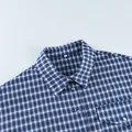 Close-up detail of the collar and buttons on a classic blue plaid cotton shirt for women. - S / Tops / Blue Plaid