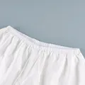 Close-up detail of white semi-sheer trousers featuring elastic waistband and drawstring - S / Bottoms / White Striped