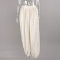 Close-up of satin fabric texture and draped harem pant design on a mannequin - S / Bottoms / Apricot