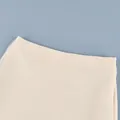 Vista detallada de la falda de satén crema con diseño elegante de malla transparente - S / Bottoms / Champán