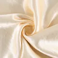Detalle macro de tela de satén oro champán con brillo sedoso y textura en espiral - S / Bottoms / Champán