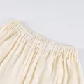 Detailopname van de elastische, geplooide tailleband van een Franse bubble-stijl broek - S / Bottoms / Abrikoos