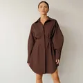 Kaukasisch model in een chique bruine overhemdjurk met lange mouwen en geplooide taille - S / Dresses / Bruin