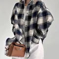 Gedetailleerd overzicht van een oversized marineblauw en wit geruit shirt met lange mouwen - S / Tops / Geruit