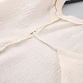 Close-up detail of soft crinkle cotton gauze fabric and seam stitching on a dress - S / Dresses / Apricot