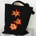 Black canvas tote bag featuring vibrant orange lily prints, ideal for daily shopping. - Orange Lily (STD2097-R Black)
