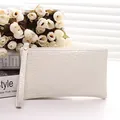 Elegante crèmekleurige clutch met krokodillenhuidtextuur en handig polsbandje detail - Broken Wit
