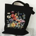 Durable black canvas tote bag featuring a vibrant watercolor wildflower print design. - Watercolor Wildflower (STD2097-V Black)