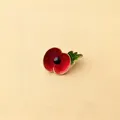 Detailed view of elegant red poppy enamel brooch with shiny gold-tone leaf accents - Red and Green