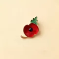 Close-up of a red poppy enamel brooch pin with golden trim and green leaf detail - Red