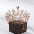 Detailzicht van de barokke koningin kroon met witte steentjes op een houten kistje - Rozegouden Strass Ronde Stijl (HG340) / Roségoud