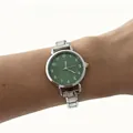Detailopname van een minimalistisch dameshorloge met groene wijzerplaat en zilveren band - Modulaire Numerieke Ronde Stijl (4675) / Donkergroen
