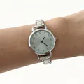Detailed view of an elegant silver stainless steel quartz watch worn on a wrist - Modular Numeric Round Style (4674) / Light Green