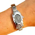 Detail view of a unique silver fish-shaped fashion watch for women worn on the wrist. - 5466-Silver Black